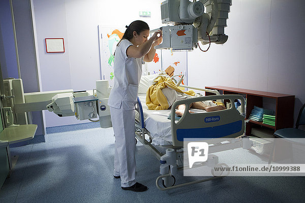 Reportage in einem radiologischen Dienst eines Krankenhauses in Haute-Savoie  Frankreich. Ein Röntgentechniker macht eine Röntgenaufnahme vom Knöchel eines bettlägerigen Patienten.