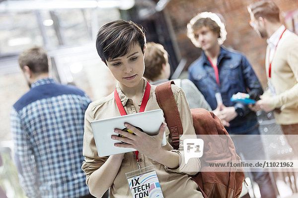 Young woman using digital tablet at technology conference