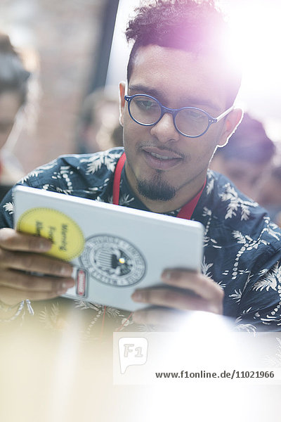 Junger Mann mit digitalem Tablett auf der Technologiekonferenz
