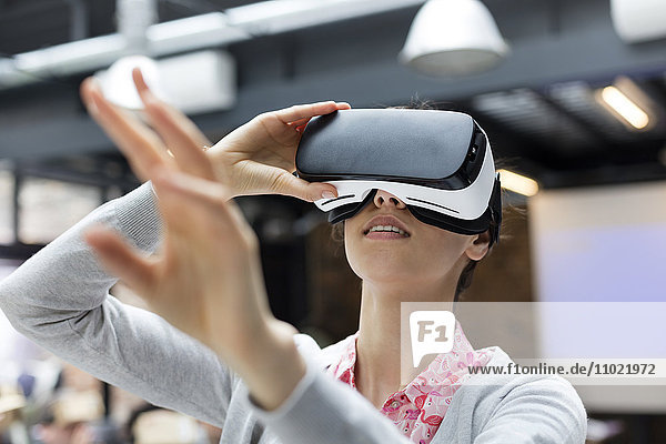 Woman trying virtual reality simulator glasses glasses reaching