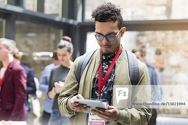 Mann mit digitalem Tablett auf der Technologiekonferenz