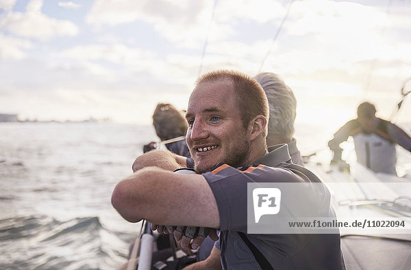 Lächelnder Mann segelt auf einem Segelboot