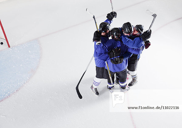 Eishockeymannschaft in blauen Uniformen feiert auf dem Eis