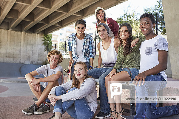 Portrait confident teenage friends hanging out at skate park