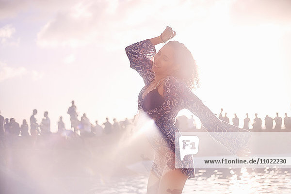 Junge Frau tanzt auf sonniger Poolparty