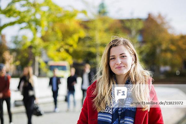 Portrait of beautiful young woman wearing red jacket outdoors