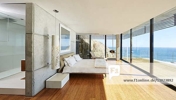 Modernes  luxuriöses Schlafzimmer mit Zugang zur Terrasse und sonnigem Meerblick