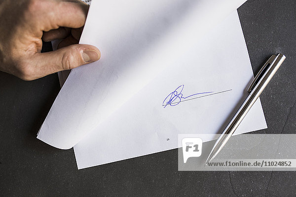 Cropped image of businessman holding document with signature