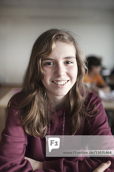 Portrait of smiling schoolgirl (12-13) in classroom