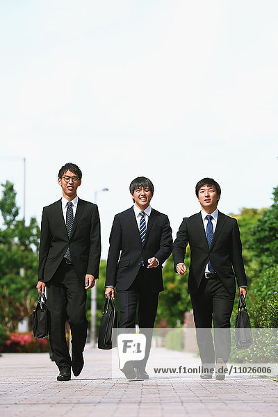 Junge japanische Geschäftsleute beim Spaziergang