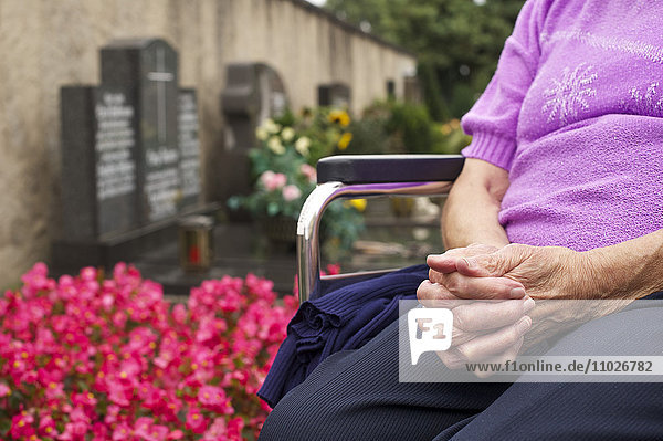 Seniorin auf dem Friedhof