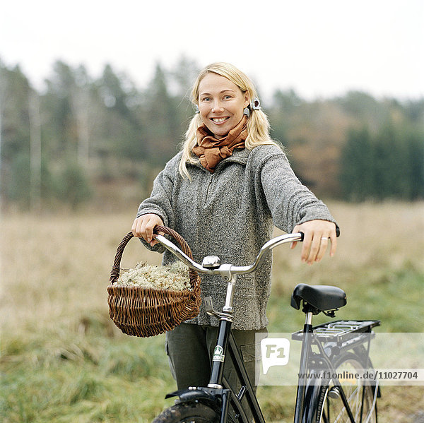 A blond woman with bike an autumn day.