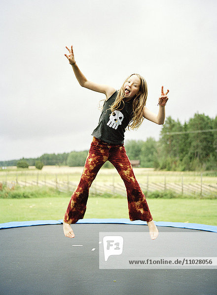 A girl jumping on a trampoline.