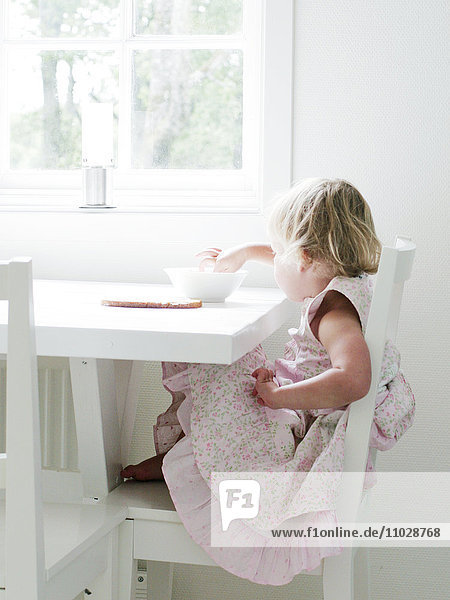 Girl sitting at table eating