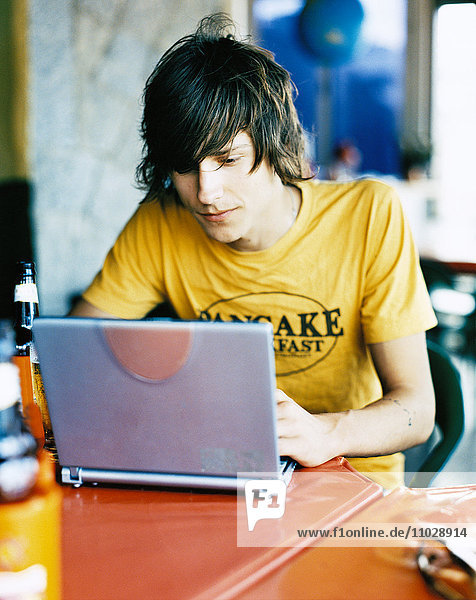 Junger Mann mit Laptop.
