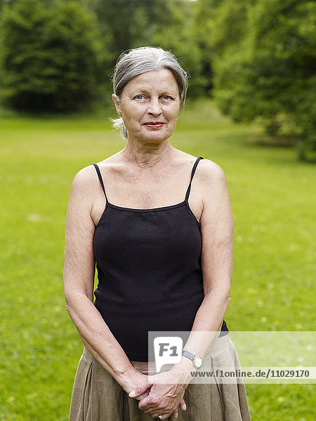 Ältere Frau im Park stehend