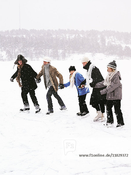 Five people skating holding hands.