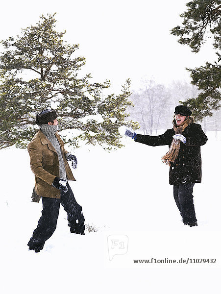 Two people in a snowball fight.
