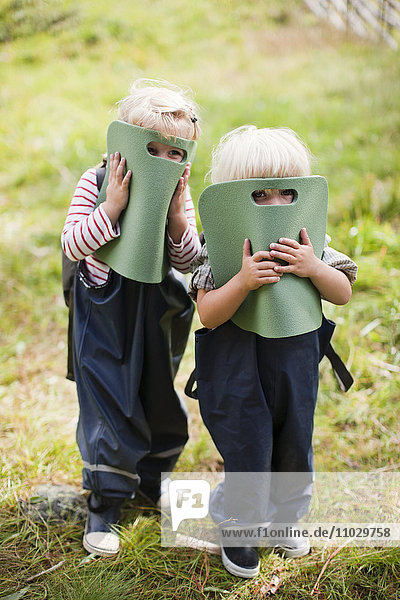Boy and girl covering faces