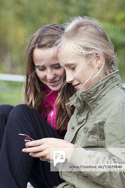 Zwei Mädchen schreiben sich eine SMS