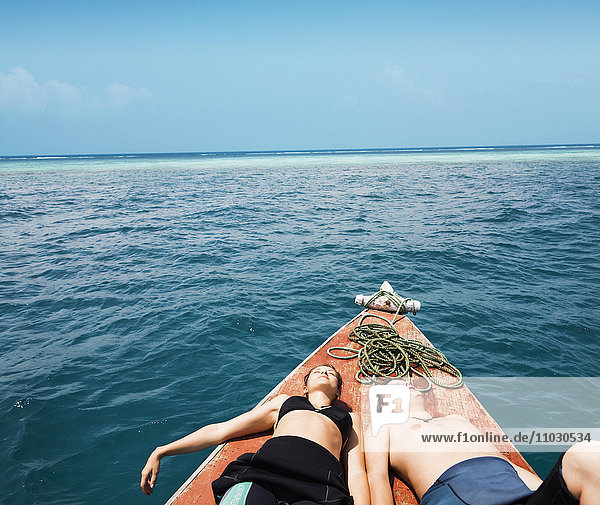 Pärchen beim Sonnenbaden auf dem Deck eines Bootes
