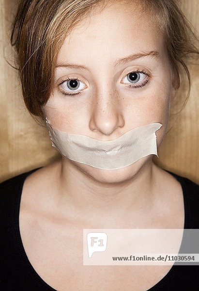 Porträt eines jungen Mädchens mit Klebeband über dem Mund