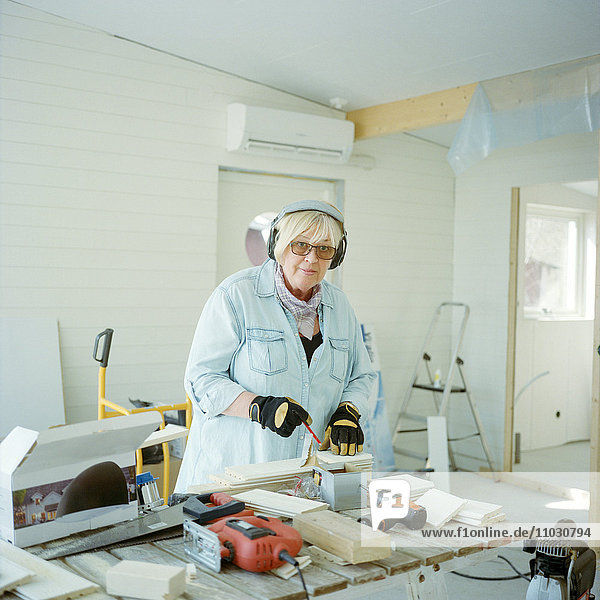 Ältere Frau bei Tischlerarbeiten