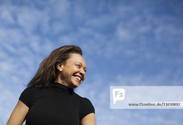 Schweden  Stockholm  Low angle view of smiling woman against sky
