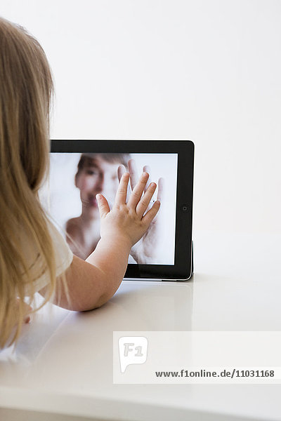 Mädchen kommuniziert mit Mutter über Tablet
