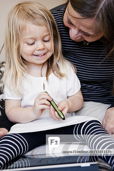 Großmutter und Enkelin zeichnen auf einem digitalen Tablet