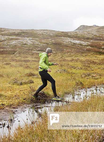 Man cross-country running in wilderness