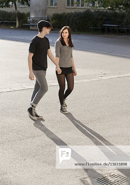 Teenage couple walking on schoolyard