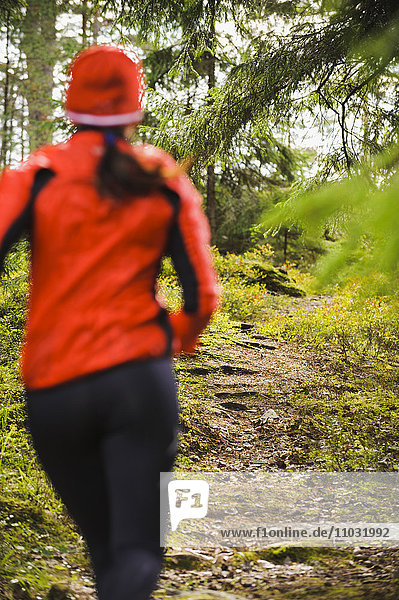 Woman jogging through forest