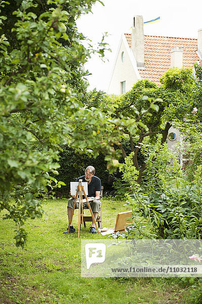 Mann malt in seinem Hinterhof