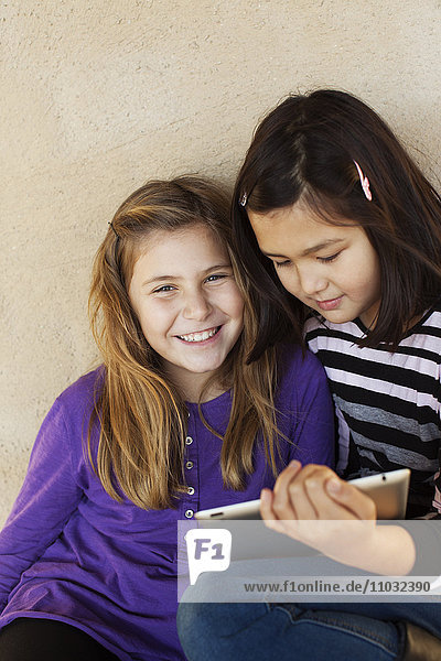 Porträt von zwei Mädchen mit digitalem Tablet