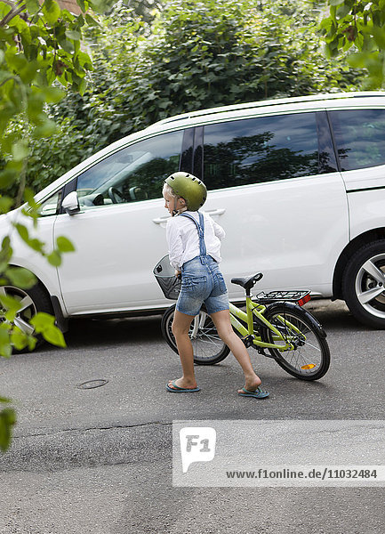Mädchen mit Fahrrad spielt auf der Straße