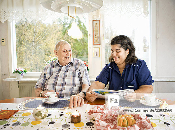 Nurse with senior man at table  Sweden