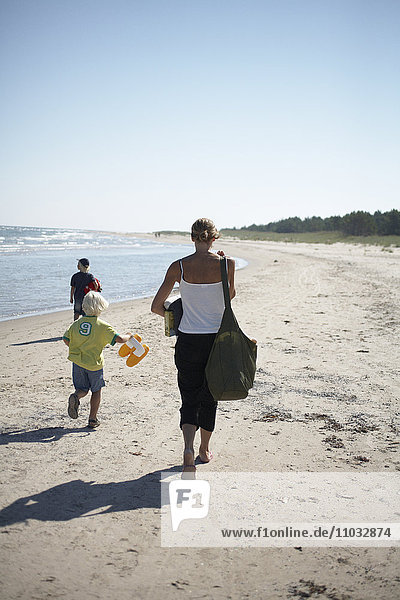 Eine Frau und Kinder am Strand.