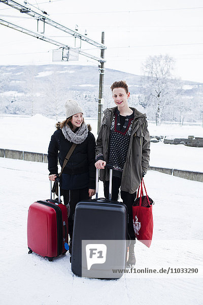 Teenager mit Koffern auf dem Bahnsteig