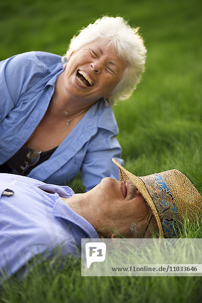 Ein älteres Ehepaar lacht draußen.