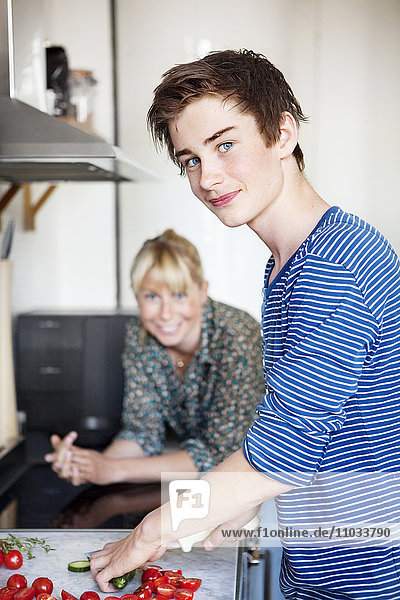 Teenage boy with mother in kitchen