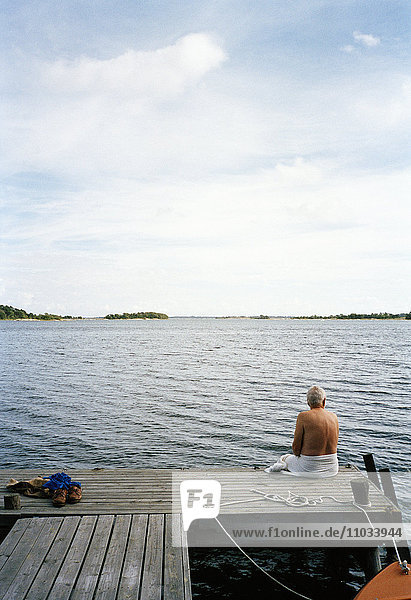 A man sitting on a pier  Stockholm archipeoago  Sweden.