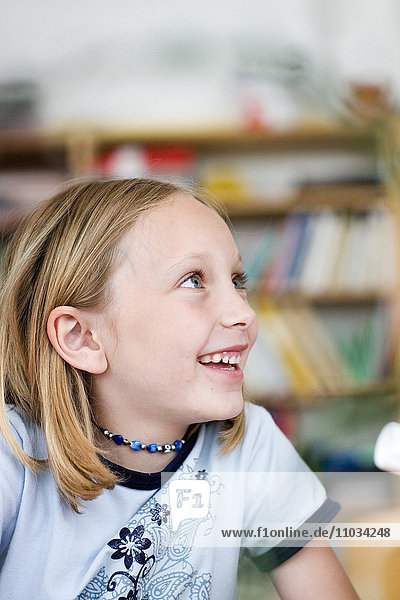 Ein lächelndes Mädchen in einem Klassenzimmer  Schweden.