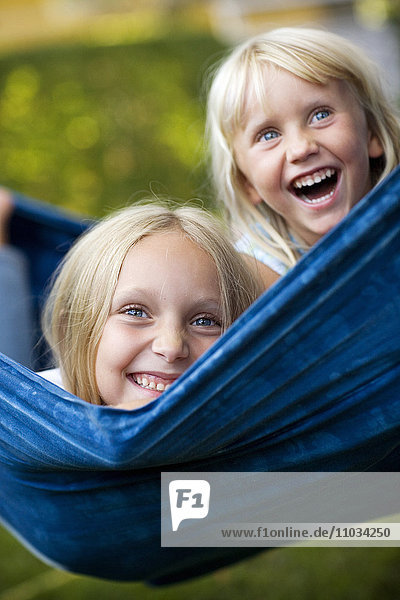 Zwei glückliche Mädchen in einer Hängematte  Schweden.