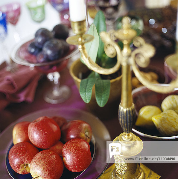 Früchte und ein Kerzenständer auf einem Tisch.