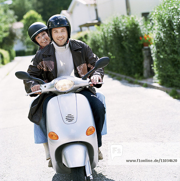 Ein Paar auf einem Motorroller.