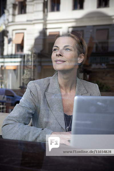 Businesswoman sitting in cafe and using laptop