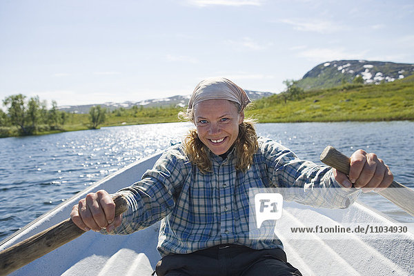 Eine Frau rudert ein Boot  Hemavan  Schweden.