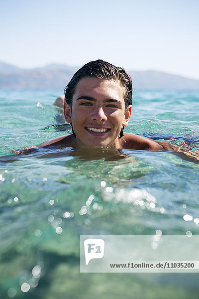 Lächelnder Jugendlicher beim Baden im Meer