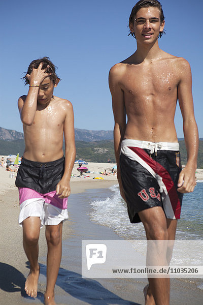 Zwei Brüder gehen am Strand spazieren